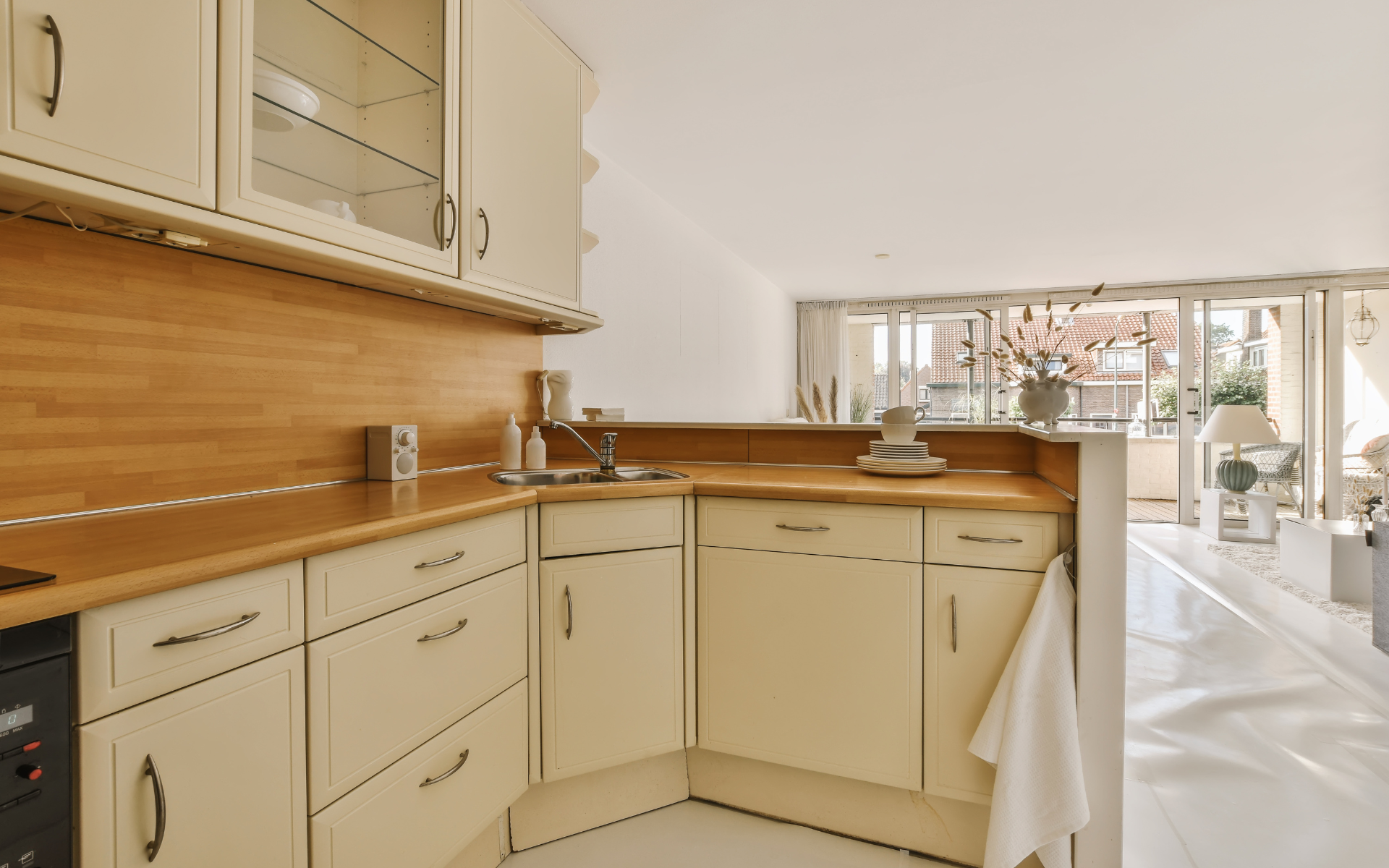 Transitional style kitchen with beige cabinets and wood countertops